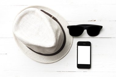 şapka güneş gözlüğü ve akıllı telefon