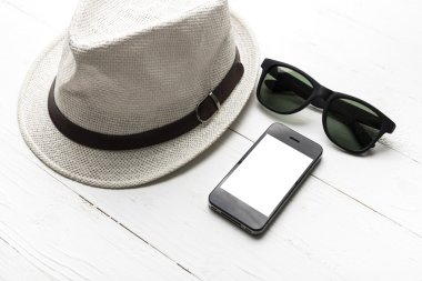 şapka güneş gözlüğü ve akıllı telefon