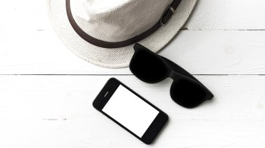 şapka güneş gözlüğü ve akıllı telefon