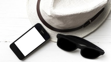 şapka güneş gözlüğü ve akıllı telefon