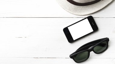 şapka güneş gözlüğü ve akıllı telefon