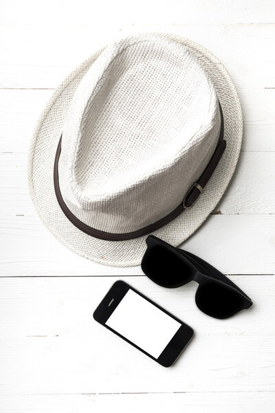 hat sunglasses and smart phone