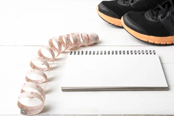 Tênis de corrida com notebook e fita métrica — Fotografia de Stock