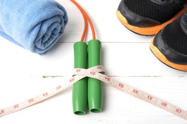 Beyaz ahşap masa üzerinde fitness ekipmanları