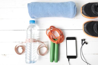 Beyaz ahşap masa üzerinde fitness ekipmanları