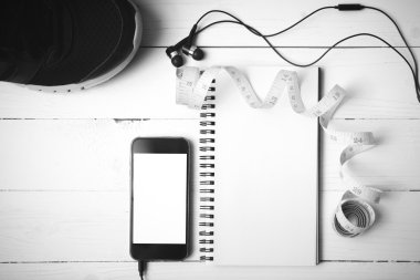 koşu ayakkabıları, bant, dizüstü bilgisayar ve telefon siyah ve beyaz ölçme 