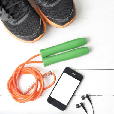Fitness Ekipmanları: koşu ayakkabıları, havlu, atlama ipi ve telefon
