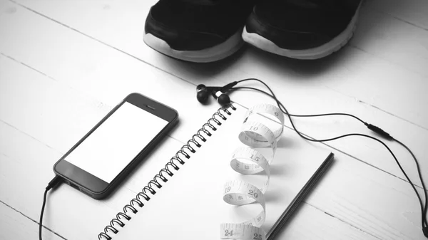 Running shoes,measuring tape,notebook and phone black and white — Stock Photo, Image
