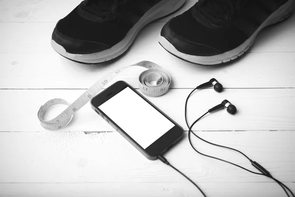 Бігове взуття, вимірювальна стрічка і телефон чорно-білий тон коло — стокове фото