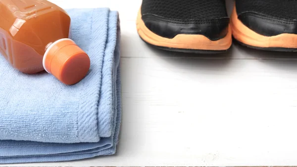 Tênis de corrida, toalha e suco de laranja — Fotografia de Stock