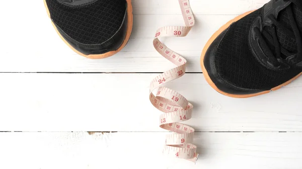 Running shoes and measuring tape — Stock Photo, Image