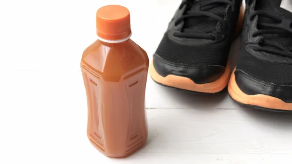 Sapatos de corrida e suco de laranja — Fotografia de Stock