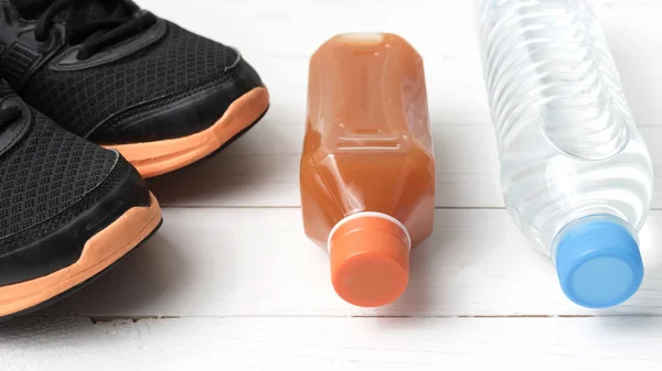 Running shoes,drinking water and orange juice — Stock Photo, Image