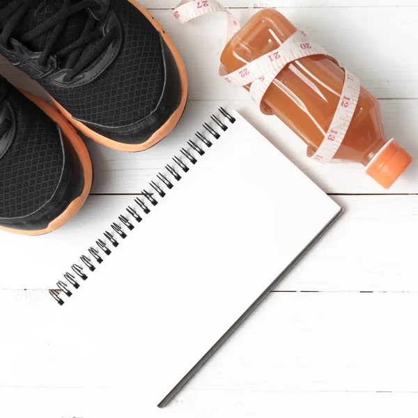 Tênis de corrida, suco de laranja, fita métrica e bloco de notas — Fotografia de Stock