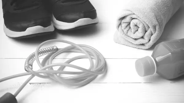 Beyaz tahta arka plan siyah ve beyaz sesi üzerinde fitness ekipmanları — Stok fotoğraf