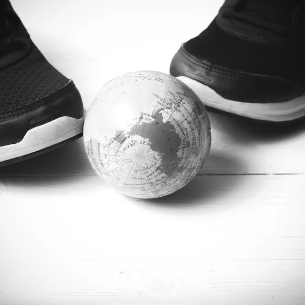 Беговая обувь и шар земли черно-белый тон стиль — стоковое фото