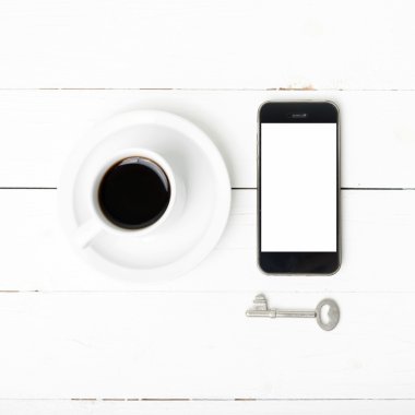 kahve fincanı ile telefon ve anahtar