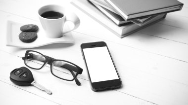 Kahve Kupası ile tanımlama bilgisi, telefon, araba anahtarı, gözlük ve kitap yığını