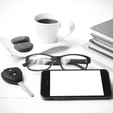 Kahve Kupası ile tanımlama bilgisi, telefon, araba anahtarı, gözlük ve kitap yığını