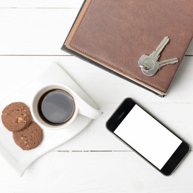 tanımlama bilgisi, telefon, kitap ve anahtar yığını ile kahve fincanı