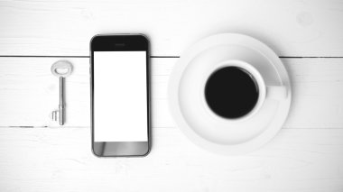 kahve fincanı ile telefon ve anahtar siyah ve beyaz renk