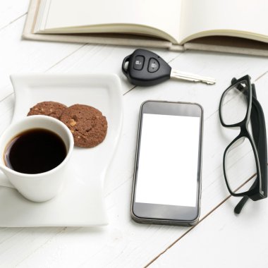 kahve fincanı ile tanımlama bilgisi, telefon, açık defter, araba anahtarı ve eyeglasse