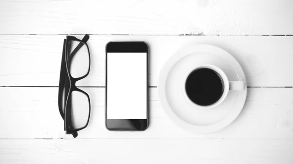 Tazza di caffè con telefono e occhiali da vista colore bianco e nero — Foto Stock