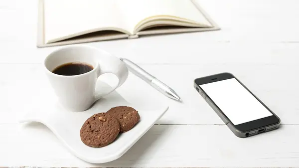 Taza de café con galletas, teléfono con portátil y pluma — Foto de Stock