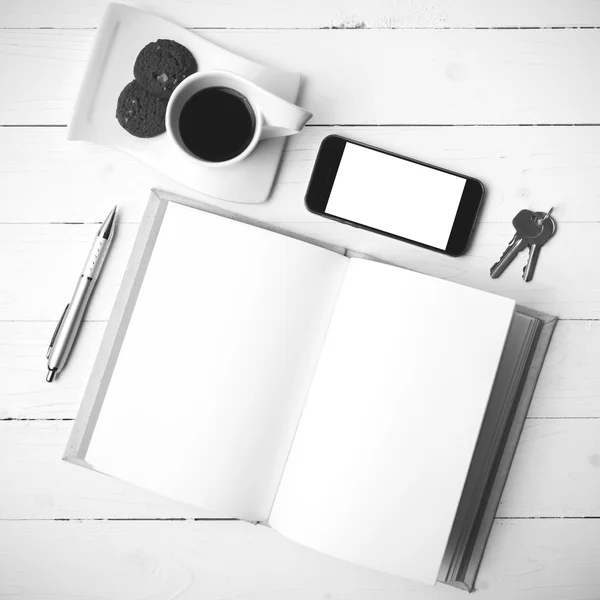 Xícara de café com biscoito, telefone, caderno e chave co preto e branco — Fotografia de Stock