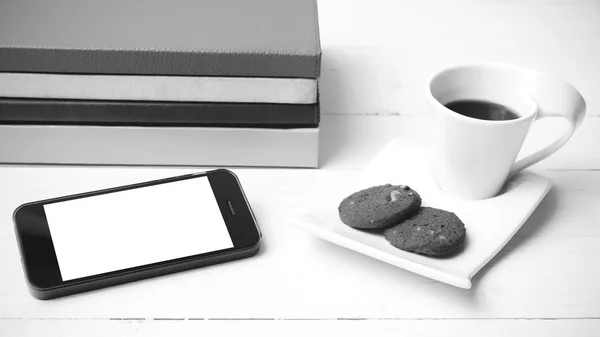 Taza de café con galletas, teléfono y pila de libro blanco y negro co — Foto de Stock