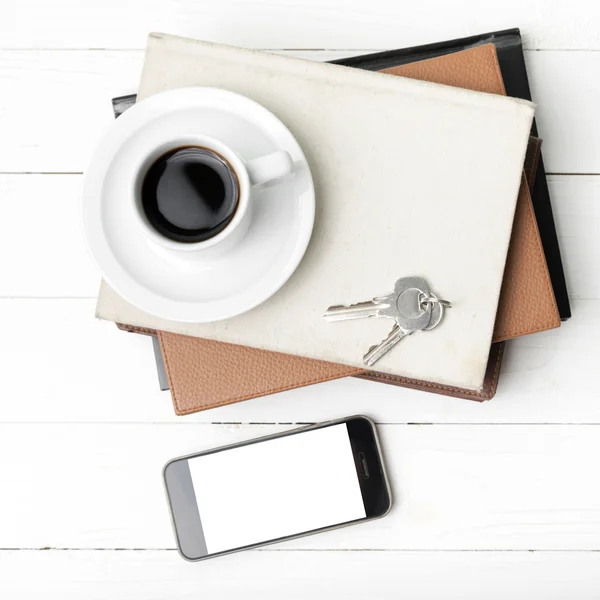 Xícara de café com telefone, chave e pilha de livro — Fotografia de Stock