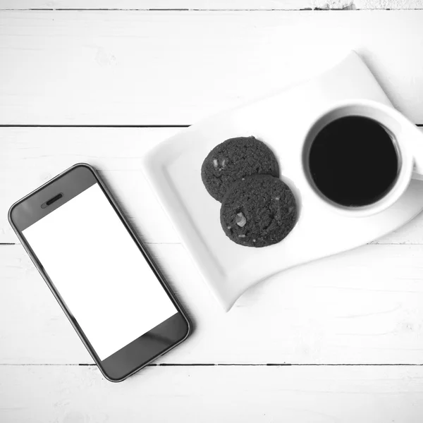 Coffee cup with cookie and phone black and white color — Stock Photo, Image