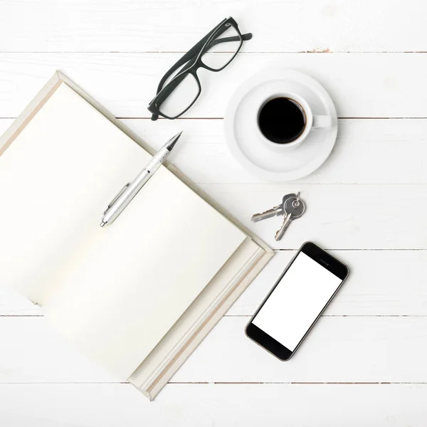 Kaffekopp med telefon, nyckel, glasögon och öppna anteckningsboken — Stockfoto