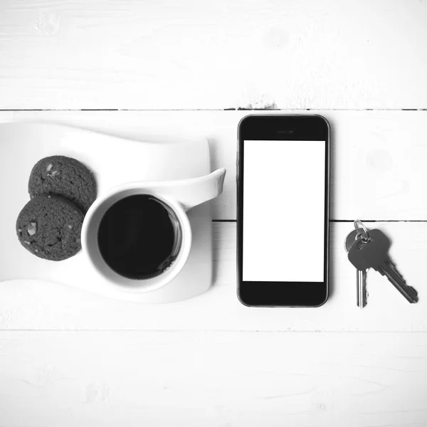 Taza de café con galletas, teléfono y llave de color blanco y negro —  Fotos de Stock