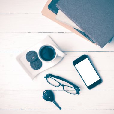 Kahve Kupası ile tanımlama bilgisi, telefon, araba anahtarı, gözlük ve kitap yığını