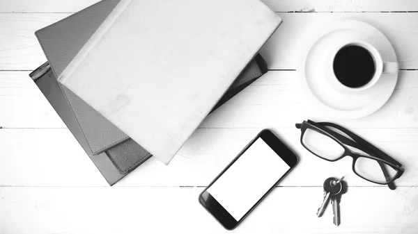 Kaffekopp med telefon, nyckel, glasögon och stack av boken svart och — Stockfoto