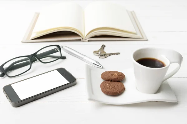 Φλιτζάνι καφέ με cookie, τηλέφωνο, ανοίξτε το σημειωματάριο, κλειδί και γυαλιά — Φωτογραφία Αρχείου
