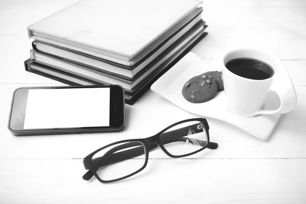 Xícara de café com biscoito, telefone de pilha de livro e óculos pretos — Fotografia de Stock