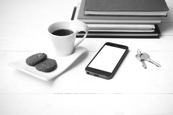 Taza de café con galletas, teléfono, pila de libro y llave negro y whi — Foto de Stock