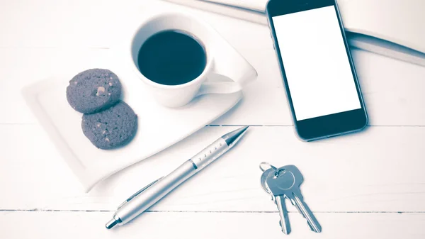 Xícara de café com biscoito, telefone, caderno e chave estilo vintage — Fotografia de Stock