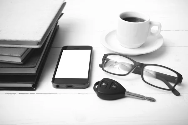 Taza de café con teléfono, llave del coche, anteojos y pila de blac libro —  Fotos de Stock