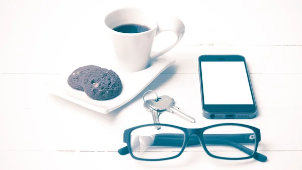 Taza de café con galletas, teléfono, anteojos y estilo vintage clave — Foto de Stock
