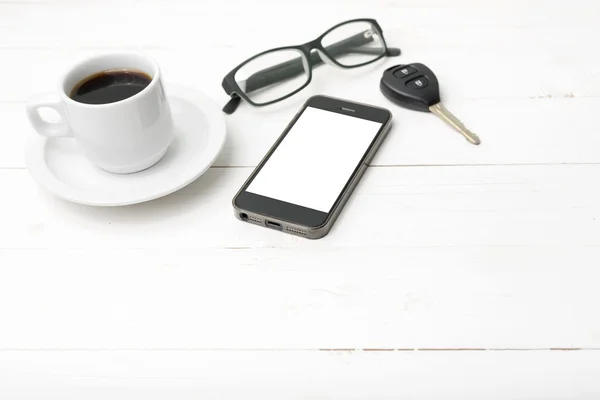 Taza de café con teléfono, anteojos y llave del coche —  Fotos de Stock