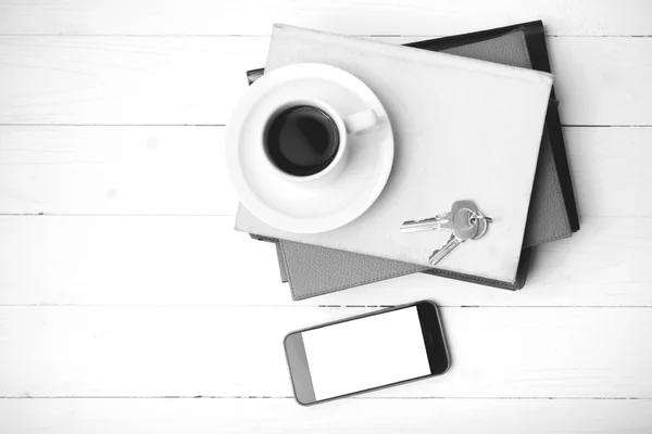 Coffee cup with phone,key and stack of book black and white colo — Stock Photo, Image