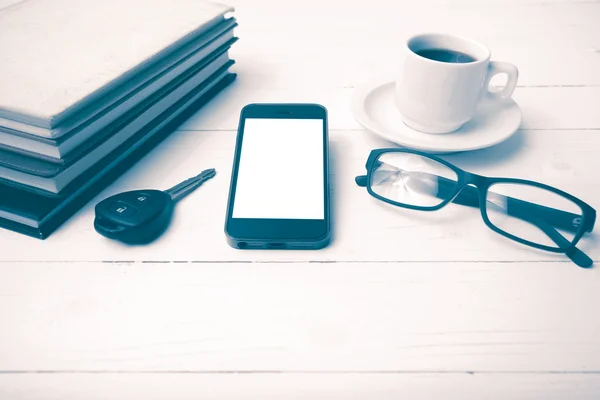 Kaffeetasse mit Telefon, Autoschlüssel, Brille und Bücherstapel — Stockfoto