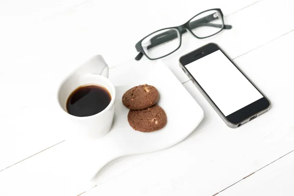 Tazza di caffè con biscotto, telefono e occhiali — Foto Stock