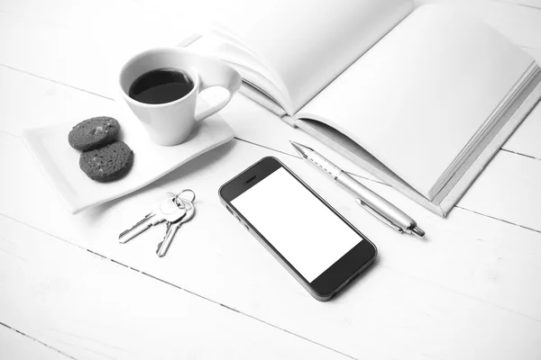 Xícara de café com biscoito, telefone, caderno e chave co preto e branco — Fotografia de Stock