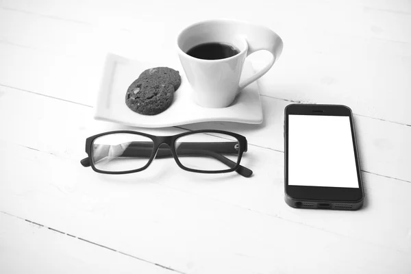 Taza de café con galletas, teléfono y gafas colo blanco y negro — Foto de Stock