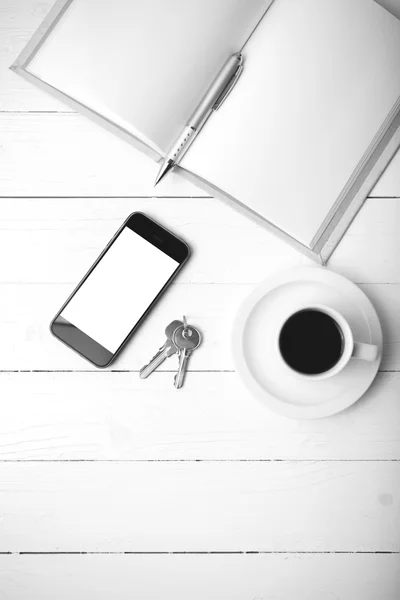 Xícara de café com telefone, chave e col aberto caderno preto e branco — Fotografia de Stock