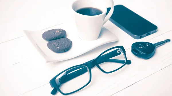 Koffiekopje met cookie, brillen en telefoon auto sleutel vintage styl — Stockfoto